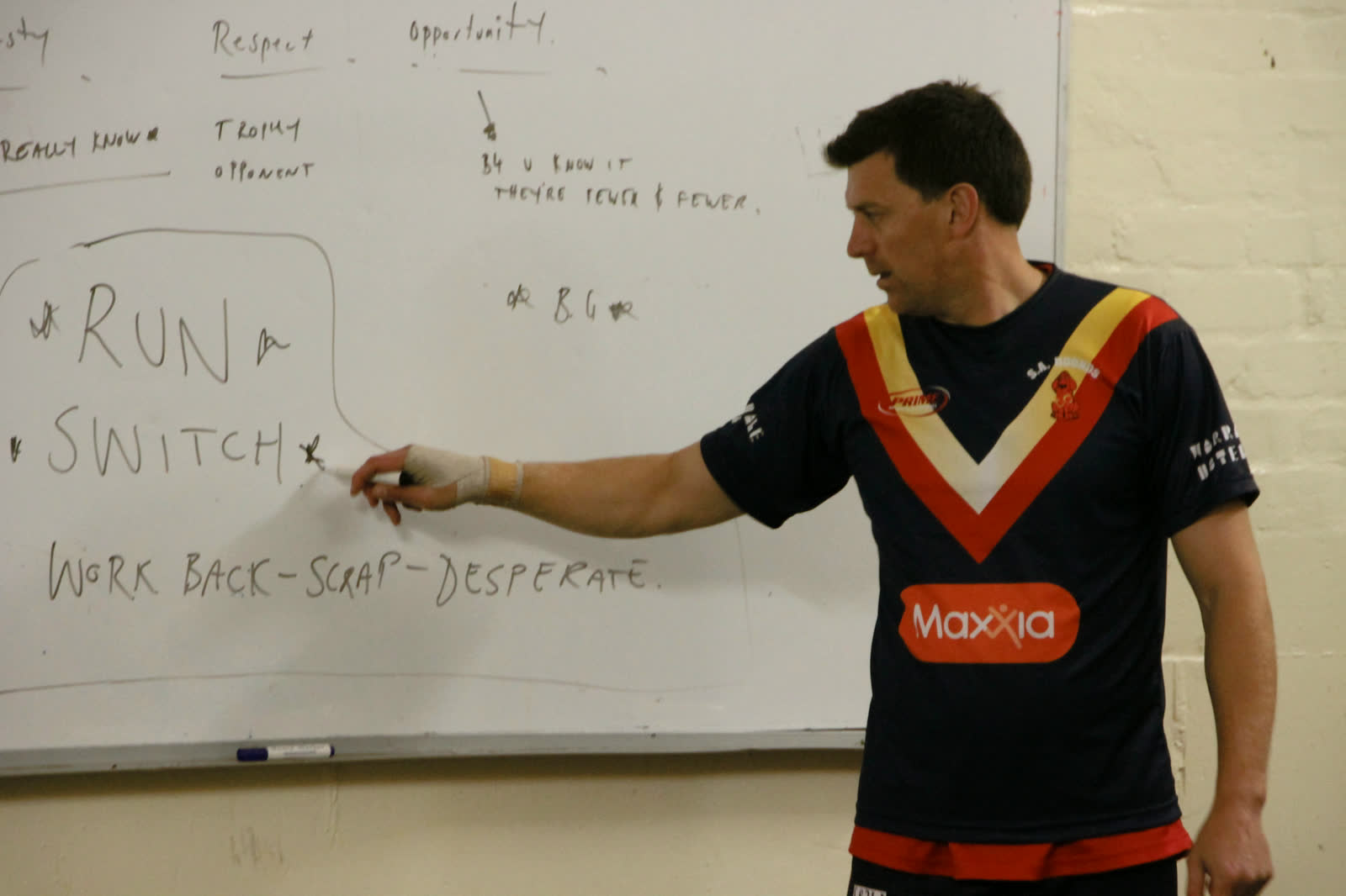 Rob Gregory coaching at the whiteboard at the police football national championships